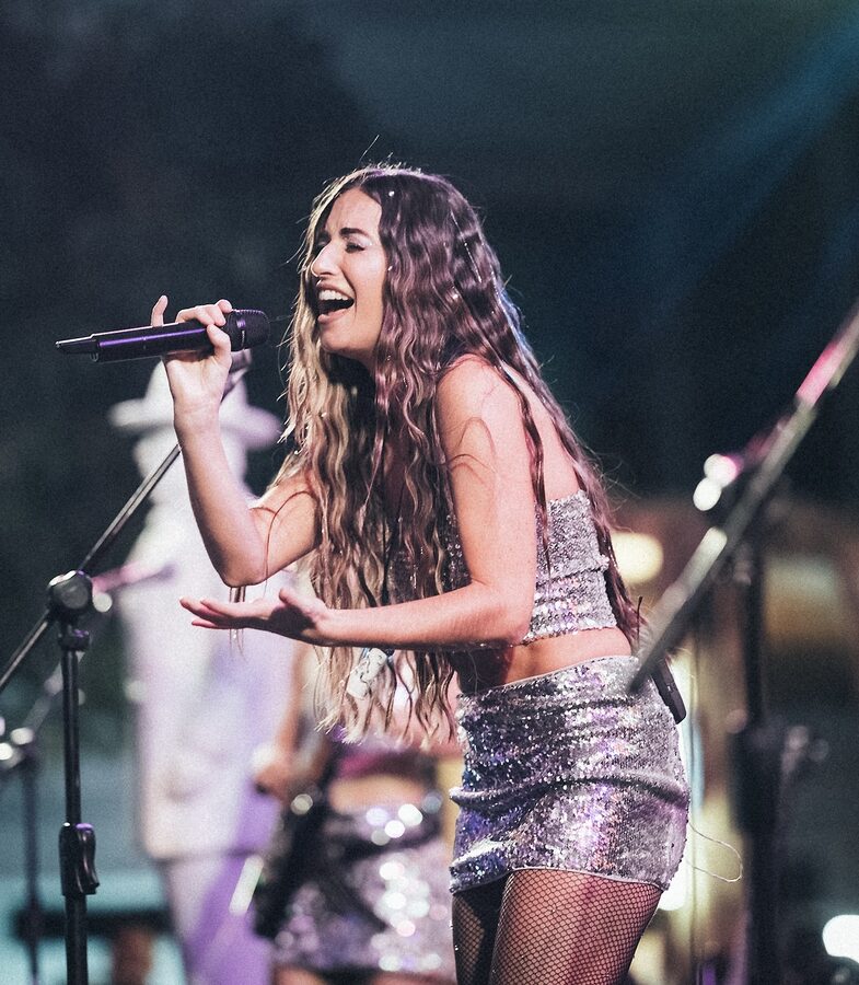 Georgia in silver sequins singing to the crowd