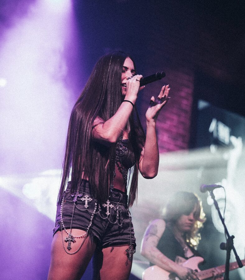 Vocals under purple lights at a Dubai club show